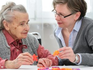 Caretaker helping a woman with dementia