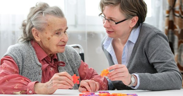 Caretaker helping a woman with dementia